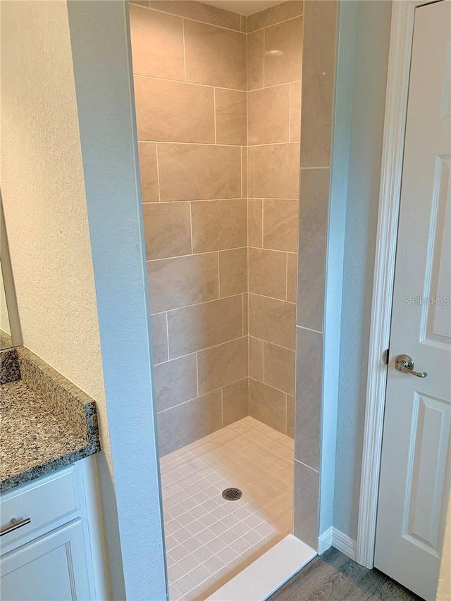 bathroom featuring vanity and tiled shower