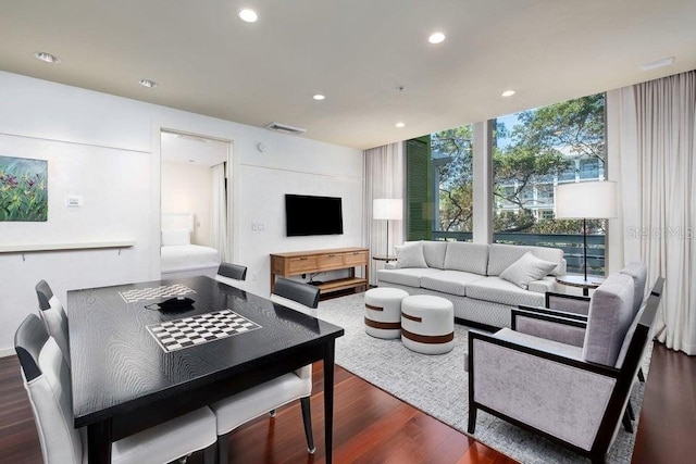 living room featuring dark wood-type flooring and a wall of windows