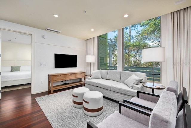 living room featuring a wall of windows and dark hardwood / wood-style floors