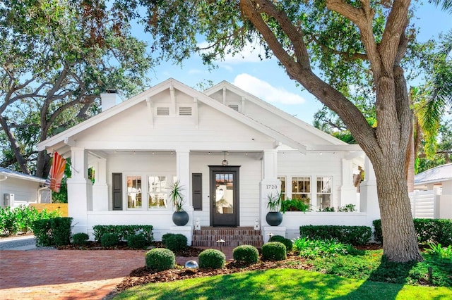 view of front of home with covered porch and a chimney