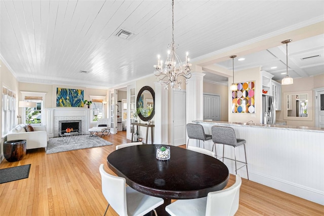 dining space with wood ceiling, plenty of natural light, a fireplace, and light hardwood / wood-style floors