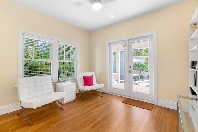 sitting room featuring french doors, ceiling fan, and light wood-type flooring