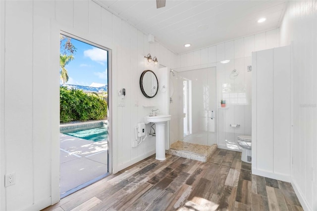 bathroom with a shower, wood-type flooring, and toilet