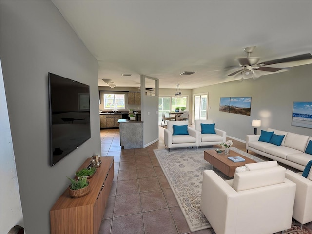 living room with tile patterned flooring, ceiling fan, and a healthy amount of sunlight