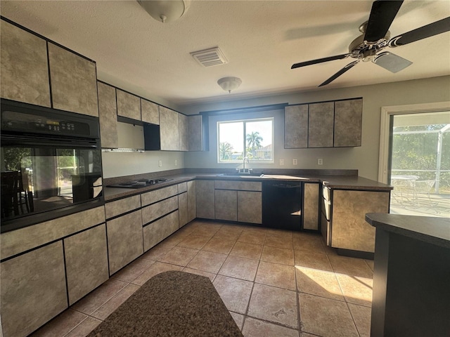 kitchen featuring black appliances, dark countertops, a sink, and visible vents