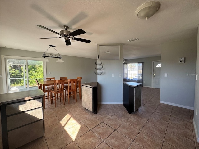 kitchen with a textured ceiling, tile patterned floors, and ceiling fan