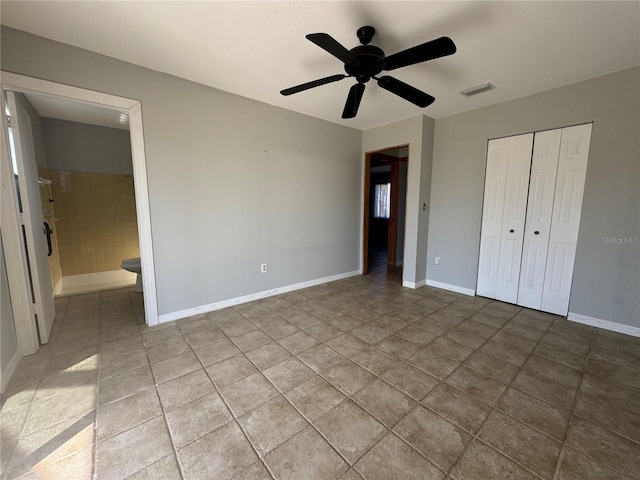 unfurnished bedroom with tile patterned floors, a closet, ceiling fan, and ensuite bathroom