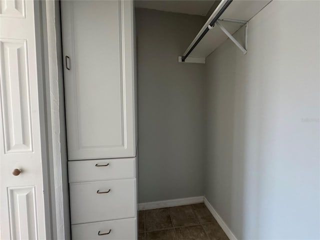 walk in closet with dark tile patterned floors