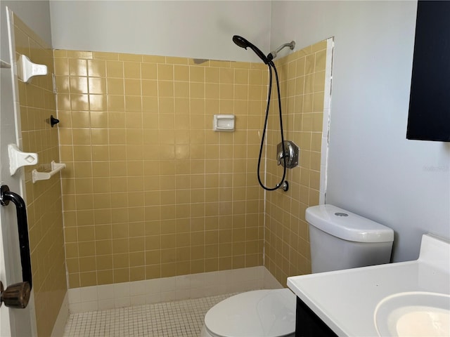 bathroom featuring vanity, toilet, and tiled shower