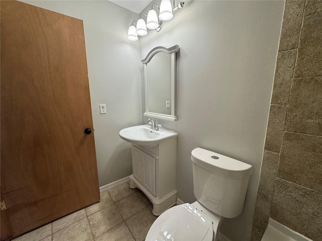 full bathroom featuring toilet, vanity, tile patterned flooring, tiled shower, and baseboards