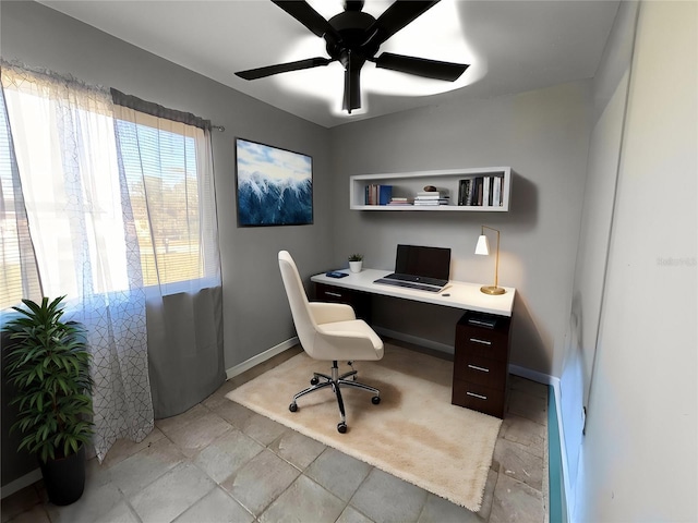 office space featuring ceiling fan and baseboards