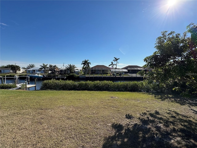 view of yard with a water view and a boat dock