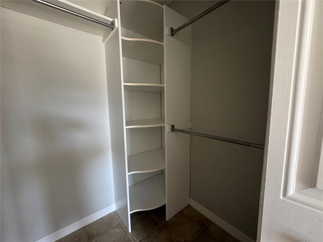 walk in closet featuring dark tile patterned floors