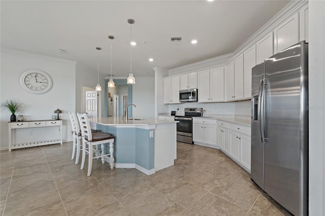 kitchen featuring sink, white cabinetry, stainless steel appliances, a center island with sink, and decorative light fixtures