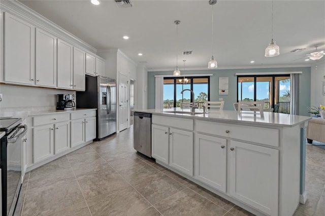 kitchen with sink, a center island, appliances with stainless steel finishes, pendant lighting, and white cabinets