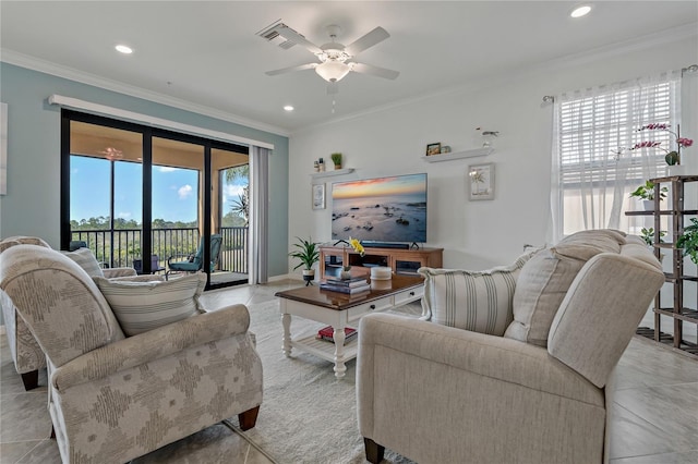 living room featuring ceiling fan, ornamental molding, and a healthy amount of sunlight