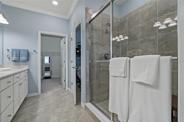 bathroom with tile patterned flooring, ornamental molding, vanity, toilet, and a shower with door