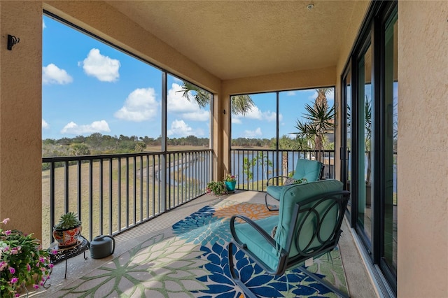 sunroom featuring a water view