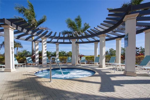 view of swimming pool featuring a hot tub, a pergola, and a patio