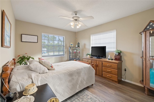 bedroom featuring ceiling fan, hardwood / wood-style floors, and a textured ceiling