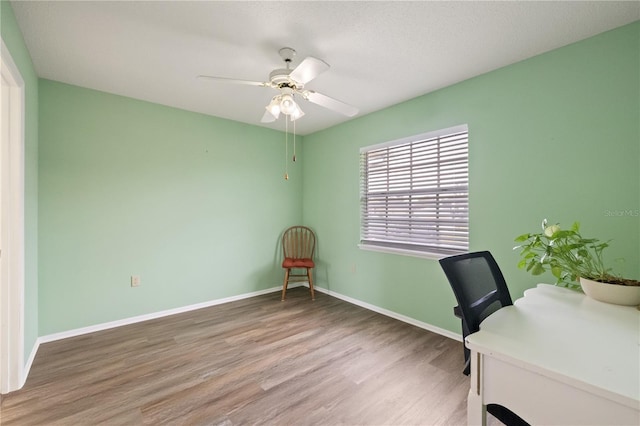 unfurnished office featuring hardwood / wood-style floors and ceiling fan