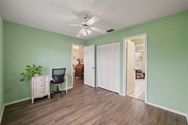 unfurnished office featuring wood-type flooring and ceiling fan