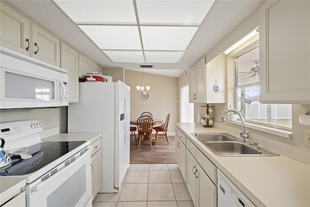 kitchen with light tile patterned flooring, sink, hanging light fixtures, a notable chandelier, and white appliances