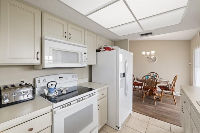 kitchen featuring a chandelier, pendant lighting, white appliances, and light tile patterned floors