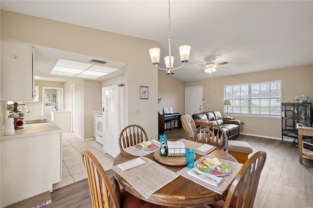 dining room with ceiling fan with notable chandelier, washer / dryer, sink, and light tile patterned floors