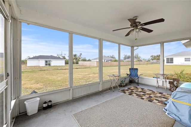 unfurnished sunroom featuring a wealth of natural light and ceiling fan