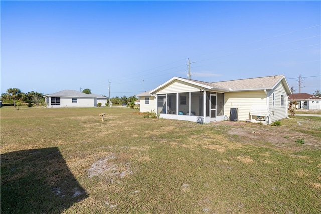 rear view of property featuring a lawn and a sunroom