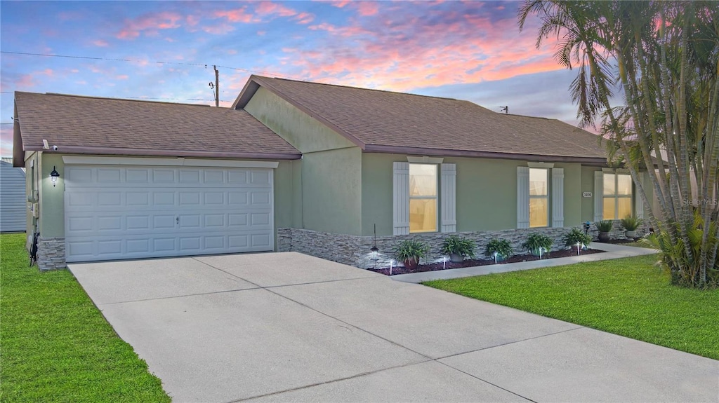 view of front of house with a garage and a lawn