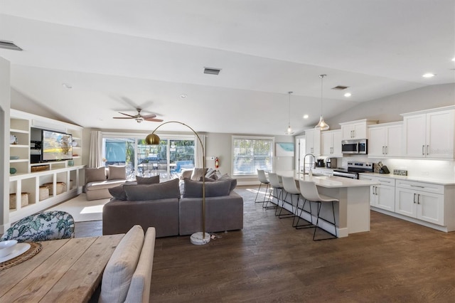 living room featuring ceiling fan, sink, dark hardwood / wood-style flooring, and vaulted ceiling