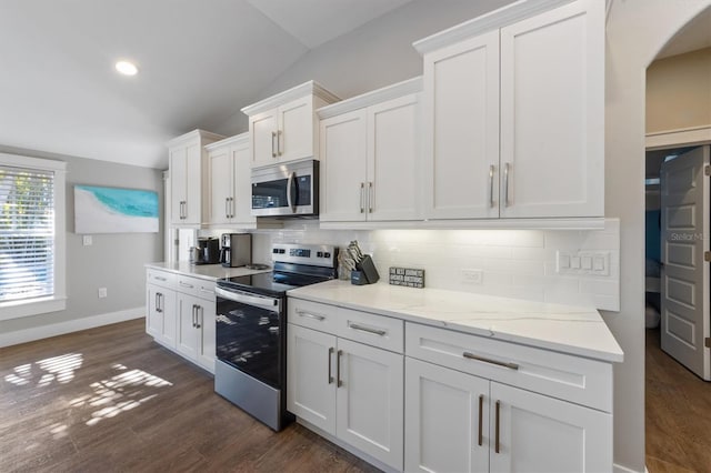 kitchen with white cabinetry, stainless steel appliances, dark hardwood / wood-style flooring, and decorative backsplash