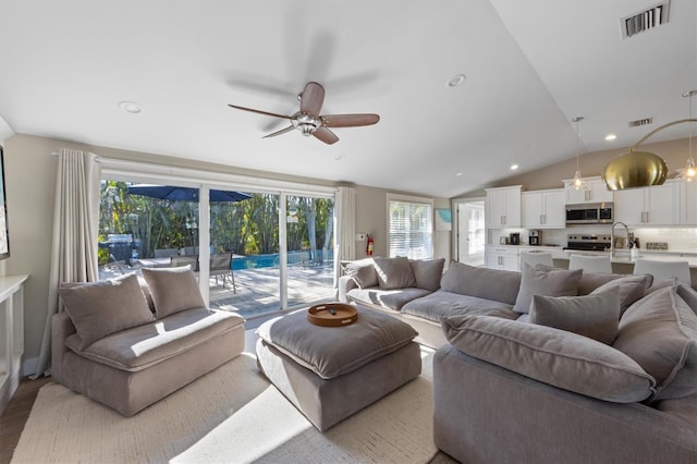 living room with sink, wood-type flooring, vaulted ceiling, and ceiling fan