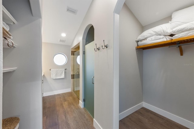 hallway with vaulted ceiling and dark hardwood / wood-style flooring