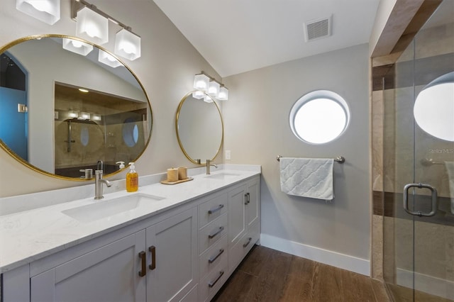 bathroom with walk in shower, lofted ceiling, wood-type flooring, and vanity