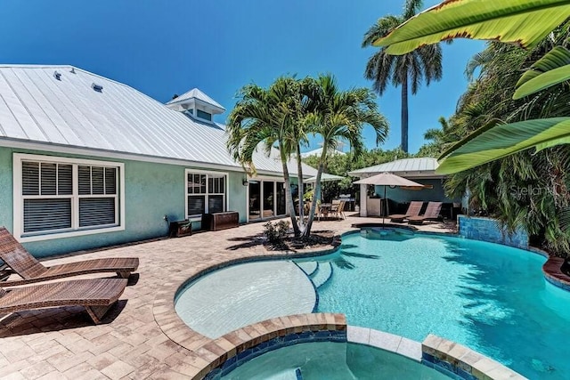 view of pool featuring an in ground hot tub and a patio