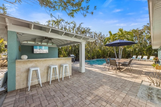 view of patio / terrace with a grill, an outdoor bar, and ceiling fan