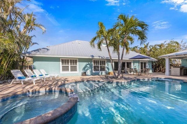 view of swimming pool featuring area for grilling, a patio, and an in ground hot tub