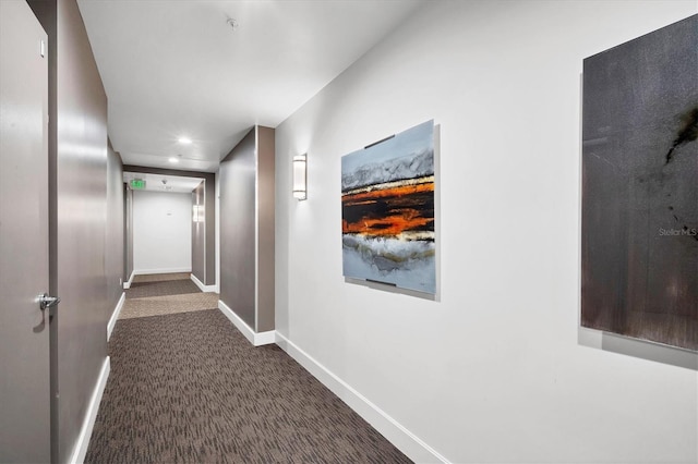 hallway featuring dark colored carpet