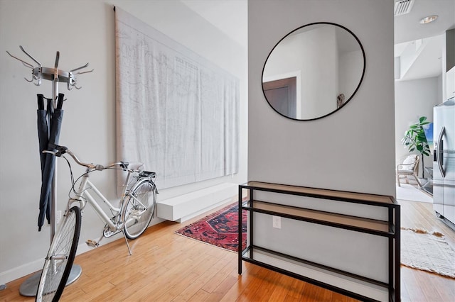 bedroom featuring stainless steel fridge with ice dispenser and hardwood / wood-style floors