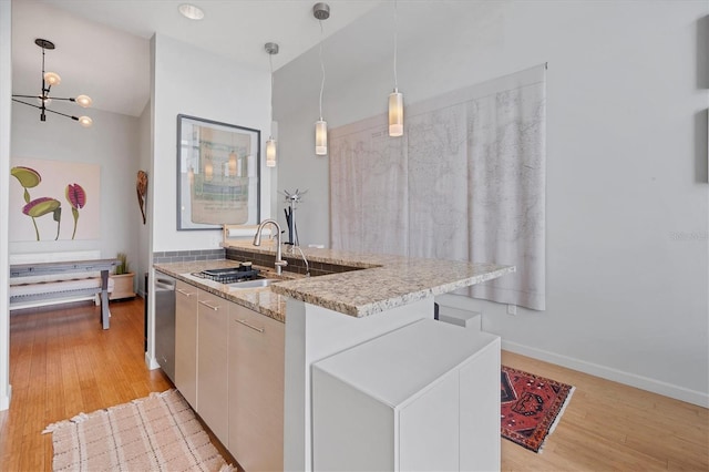 kitchen with pendant lighting, white cabinetry, a center island, and sink