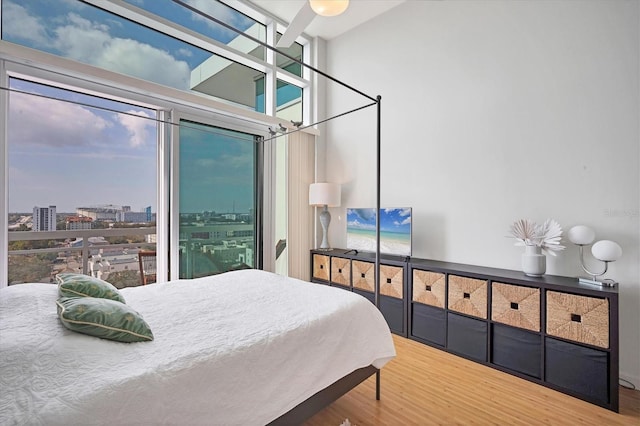 bedroom featuring hardwood / wood-style flooring and a wall of windows