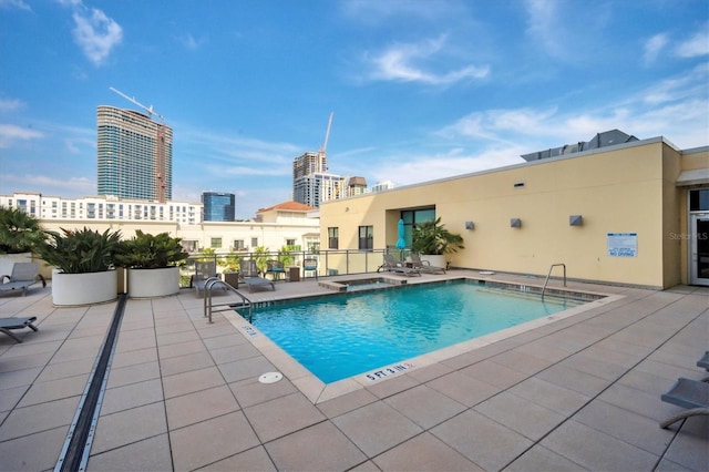 view of swimming pool with a community hot tub and a patio area