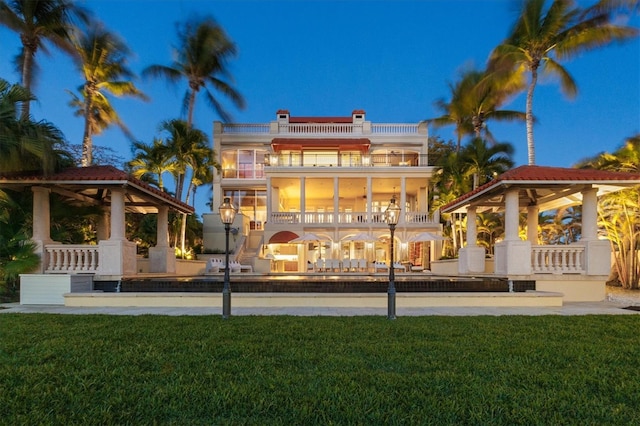 back of house featuring a yard, a gazebo, a patio, and a balcony