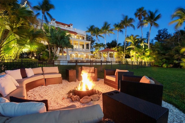 patio terrace at dusk with an outdoor living space with a fire pit