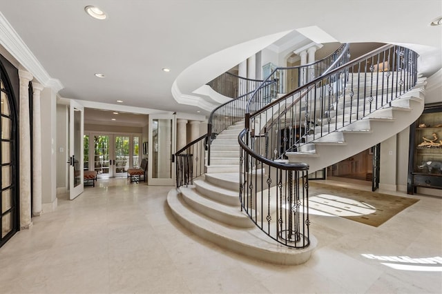 stairway with french doors, crown molding, and ornate columns