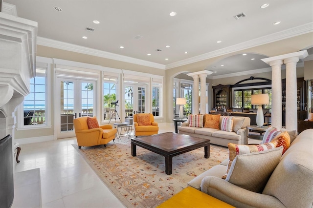 tiled living room featuring crown molding, decorative columns, and french doors