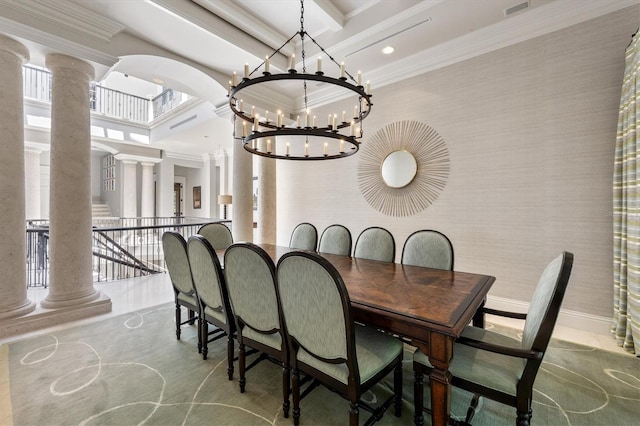 dining room featuring crown molding, a chandelier, and ornate columns